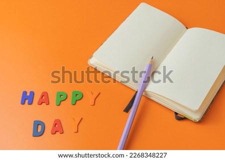 Happy day words made with colored letters and a pad to write a text