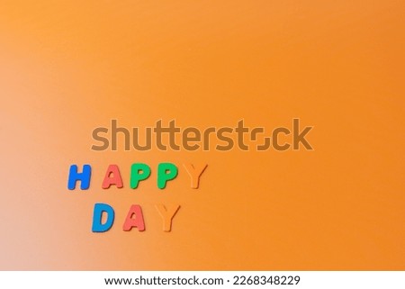 Orange background with happy day message made with colored letters