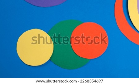 Multicolor cardboard cut circles on blue