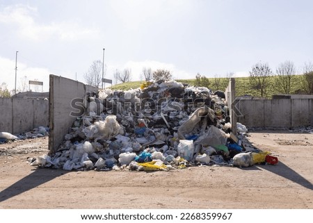 Landfill site, a pile of stinky different junk disposal in the concrete section for unsorted waste materials Royalty-Free Stock Photo #2268359967