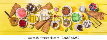 Ice cream festival background, Summer ice cream buffet with various gelato sundaes flavors. sweet toppings and sprinkles, high-colored yellow wooden background to view copy space
