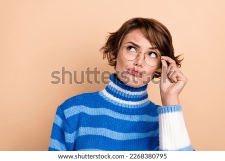 Photo of minded person arm touch eyeglasses look empty space contemplate isolated on beige color background