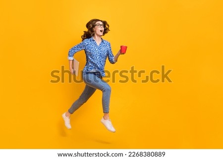 Full size profile photo of amazed girl hold laptop coffee mug jump run empty space isolated on yellow color background