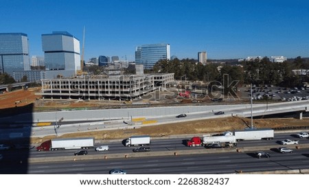 Large construction sites of high-rise office buildings and highway along Interstate 285 (the Perimeter) and Ashford Dunwoody road in midtown Atlanta, Georgia, USA. Aerial view skylines, busy traffic