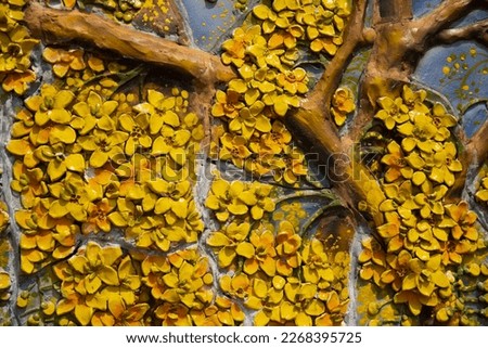 Detail of a wall decorated with yellow orchids and leaves