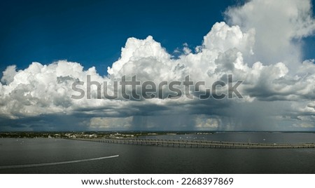 Stormy clouds forming from evaporating humidity of ocean water before thunderstorm over traffic bridge connecting Punta Gorda and Port Charlotte over Peace River. Bad weather conditions for driving Royalty-Free Stock Photo #2268397869