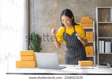Young pretty asian start up business woman in apron working with online parcel box warehouse selling online product with social media influencer people with subscriber and followers