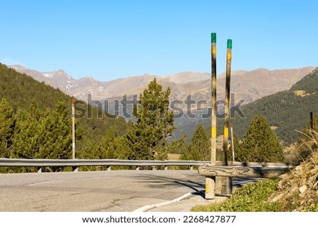 road in the mountains, with road signs, security barriers and snow poles, view of the mountains