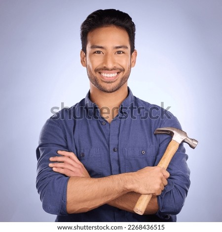 Man, studio and portrait with tools or hammer for handyman, maintenance or repair work with smile. Happy asian model person on purple background arms crossed for engineer, mechanic or technician job