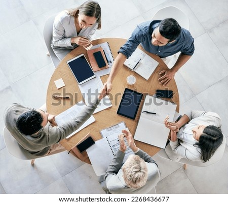 We strive to become better than we are. Shot of businessmen shaking hands during a team meeting in a modern office. Royalty-Free Stock Photo #2268436677