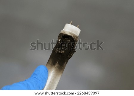 Substandard materials of ledtube a led tube light neon lamp, a burnt led lamp tube due to bad materials, substandard materials concept, hazards of light lamps, fire and industrial security concept Royalty-Free Stock Photo #2268439097