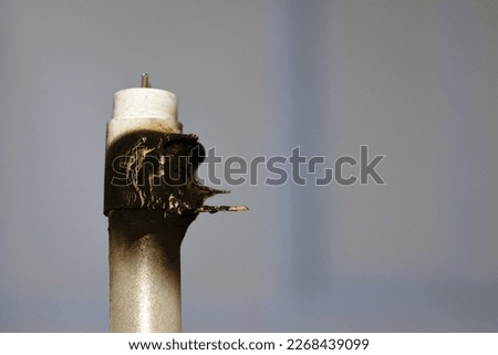 Substandard materials of ledtube a led tube light neon lamp, a burnt led lamp tube due to bad materials, substandard materials concept, hazards of light lamps, fire and industrial security concept Royalty-Free Stock Photo #2268439099
