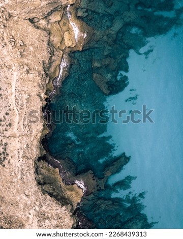 Aerial picture of the coastline of the Spanish island of Majorca taken straight from top during sunset (portrait format).