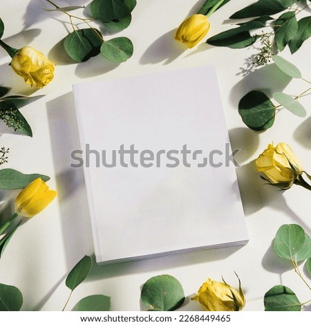 a plain white book with a floral background around it