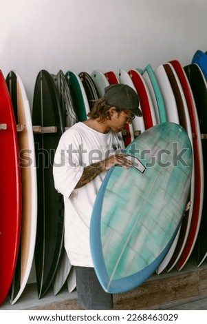 Man choosing a surfboard in a surfboard shop