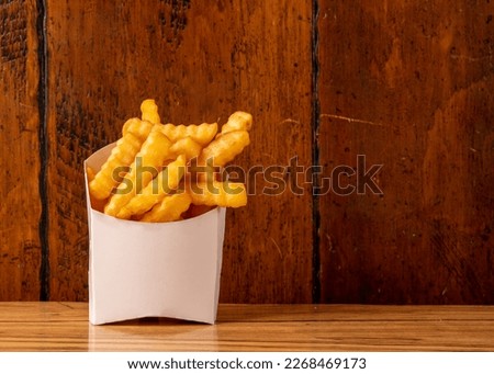 Crinkle cut fries in a box Royalty-Free Stock Photo #2268469173