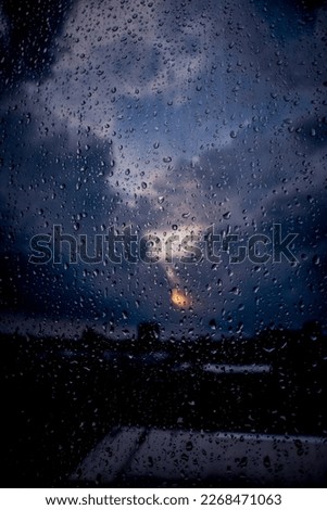 Raindrops on the window with background of sunlight behind the clouds