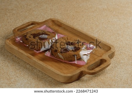 Cookies homemade wrap in plastic with brown background. Kukis 