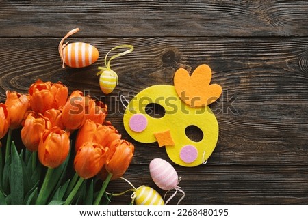 Spring tulips and multicolored Easter eggs on a wooden background. Easter background. Copy space. Easter eggs flat lay on rustic table. Easter concepts