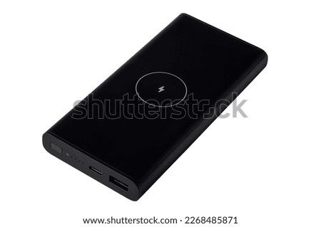 Black power bank with wireless charging sign, side with connectors and buttons. Royalty-Free Stock Photo #2268485871