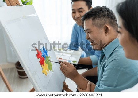 Asian happy family draw picture with young son in living room at home. Beautiful loving mother and father take care and teach young man patient to painting artwork indoors at house. Lifestyle activity