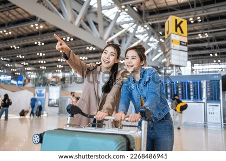 Asian young women passenger walk in airport terminal to boarding gate. Attractive beautiful female tourist friends feeling happy and excited to go travel abroad by airplane for holiday vacation trip. Royalty-Free Stock Photo #2268486945