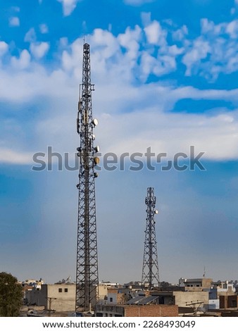 A photo taken from Manga Mandi, a city in Pakistan showing two towers blue sky background and stock photo 