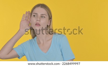 Casual Young Woman Trying to Listen Secret, Yellow Screen