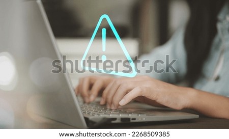 Businessman using computer laptop with triangle caution warning sing for notification error and maintenance concept.