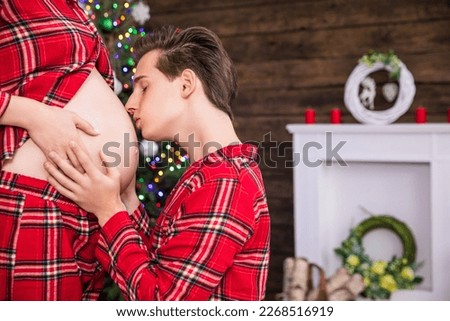 A man kneels before his wife and kisses her pregnant belly. Royalty-Free Stock Photo #2268516919