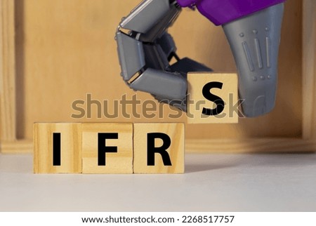 wooden cubes with the word IFRS on financial background with chart, calculator, pen and glasses, business concept.