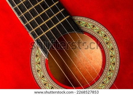Close-up. A part of a red acoustic guitar. Background. 