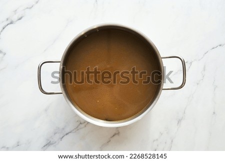 Vegetable stock in the pot on white background. Top view