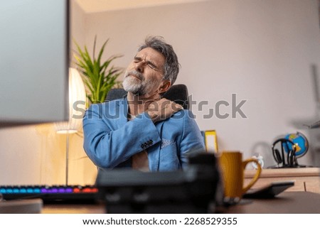 People, healthcare and problem concept - unhappy man suffering from neck or shoulder pain at office. Handsome mature man suffering from shoulder pain in office. Royalty-Free Stock Photo #2268529355