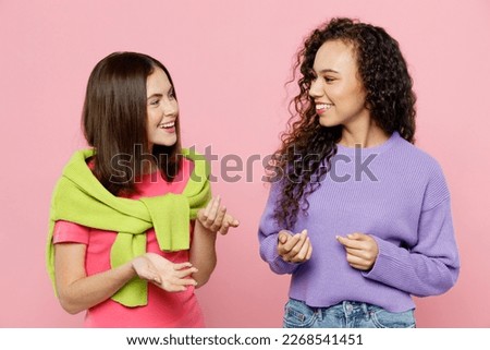Young two friends smiling happy fun cool joyful women 20s wear green purple shirts looking to each other together talking speaking isolated on pastel plain light pink color background studio portrait Royalty-Free Stock Photo #2268541451
