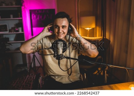 A portrait of one young man in his home podcast studio at night