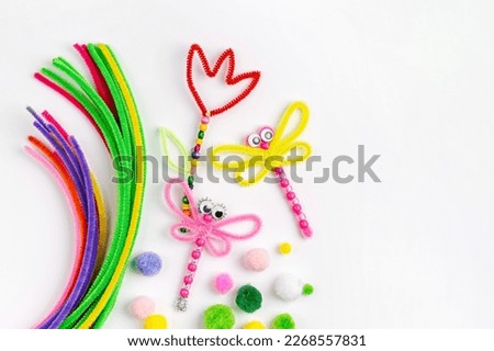 Beaded Pipe Cleaner flowers and dragonflies. Easy spring kids crafts. Different multi-colored supplies and materials for DIY art activity for kids. Children's crafts, creativity and  hobby.  Royalty-Free Stock Photo #2268557831