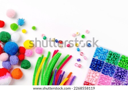 Set for children's crafts. Pipe Cleaners, beads and colorful pom-poms. Different multi-colored supplies and materials for DIY art activity for kids. Motor skills, creativity and  hobby. Royalty-Free Stock Photo #2268558119