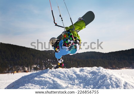 Man making hand stand on snowdrift winter snowkiting on a frozen lake Royalty-Free Stock Photo #226856755