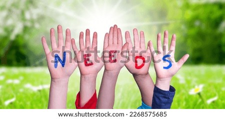 Children Hands Building Word Needs, Grass Meadow Royalty-Free Stock Photo #2268575685