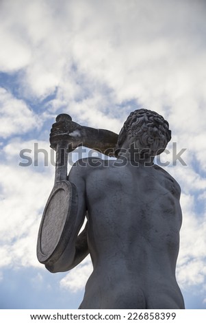 Tennis player. Marble statue and sky