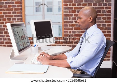 Side view of concentrated male photo editor using computer in the office