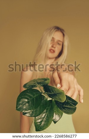 Blonde freckles woman and natural make-up holding leaves