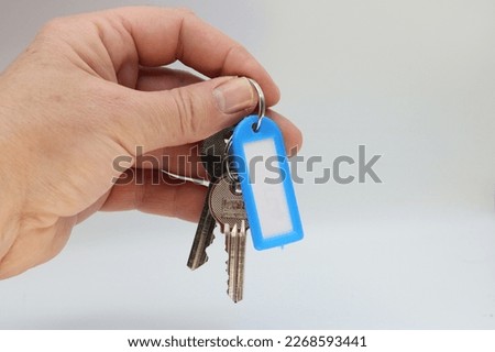 Keys with sign in hand on white background