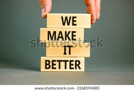 We make it better symbol. Concept words We make it better on wooden blocks. Beautiful grey table grey background. Businessman hand. Business we make it better concept. Copy space.