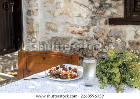 National Cretan, Greek snack (dakos). Crackers with grated tomatoes, feta cheese, oregano, olives and olive oil on a table in the patio close-up Royalty-Free Stock Photo #2268596359