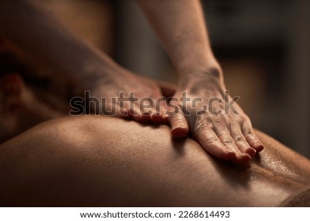 Hands of masseuse applying oil on back of young woman Royalty-Free Stock Photo #2268614493