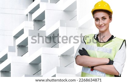 Portrait of manual woman worker is standing with confident with blue working suite dress and safety helmet in front exterior white concrete pattern wall building background.