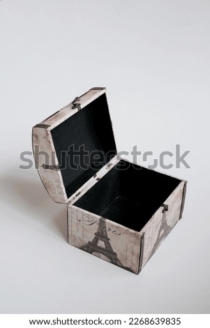
a box, with a picture of the eiffel tower. box resembling a place for jewelry