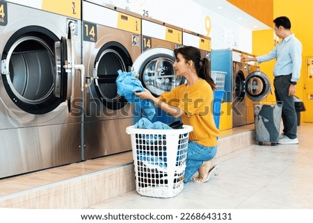 Asian people using qualified coin operated laundry machine in the public room to wash their cloths. Concept of a self service commercial laundry and drying machine in a public room. Royalty-Free Stock Photo #2268643131
